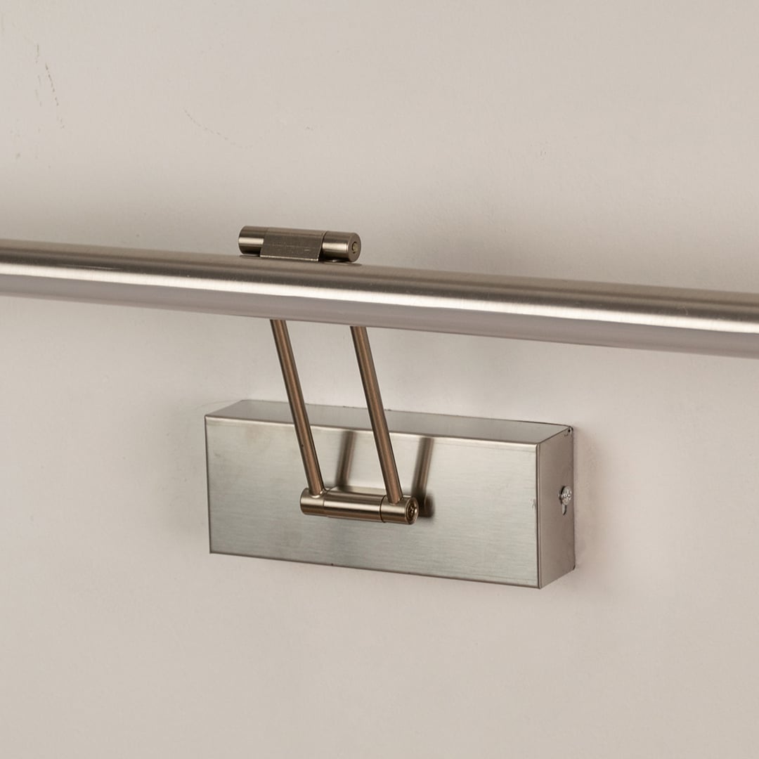 Closeup view of silver picture light highlighting smooth metal body and adjustable arm for focused picture and wall lighting.